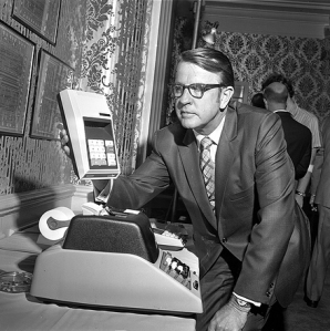 Robert Anderson with the computer of his day, standing over the old computer of his day.